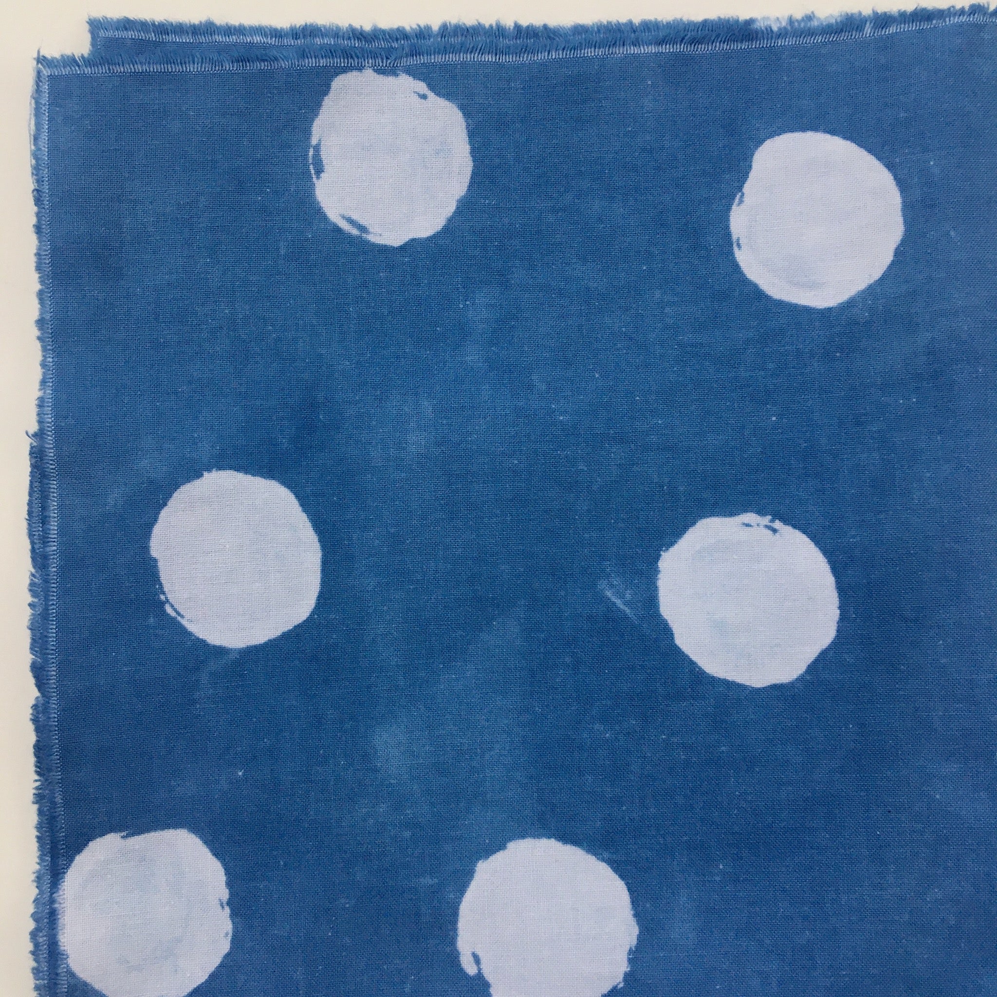 Fabric example dyed with clay resist: deep indigo blue with large white polka dots